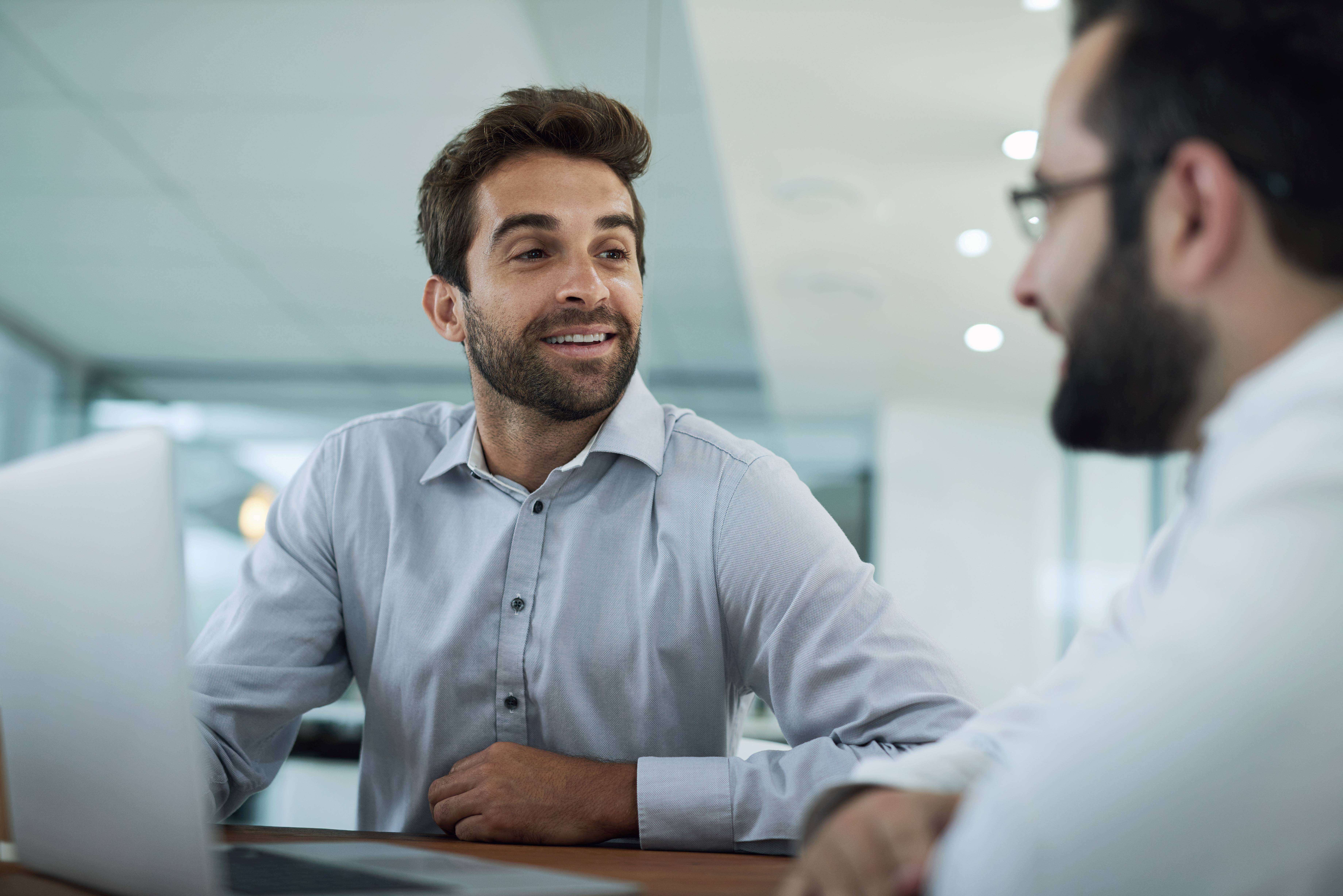 Office Staff Discussing Cybersecurity At A Desk