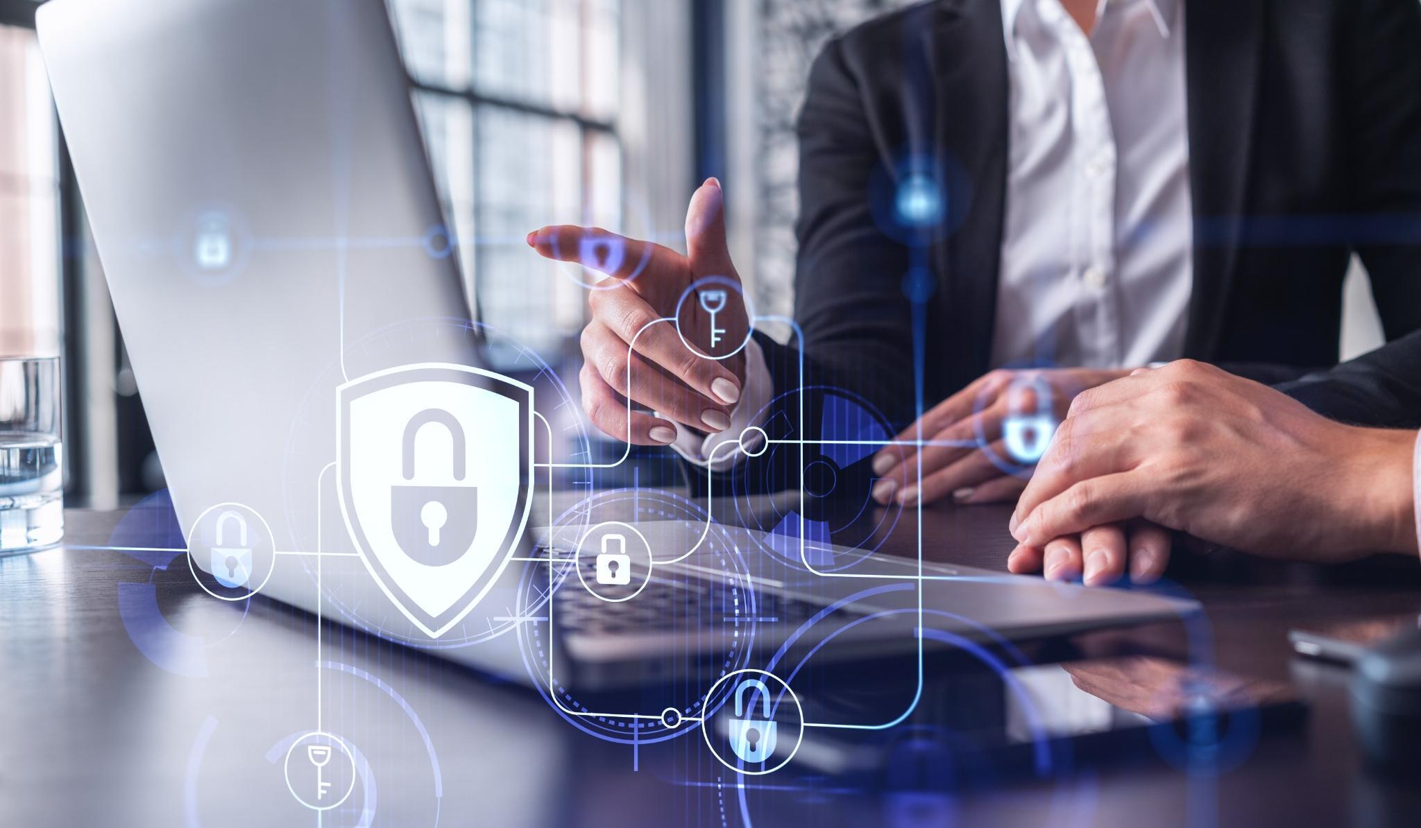 Picture of a man on a laptop with cybersecurity symbols overlayed onto the image