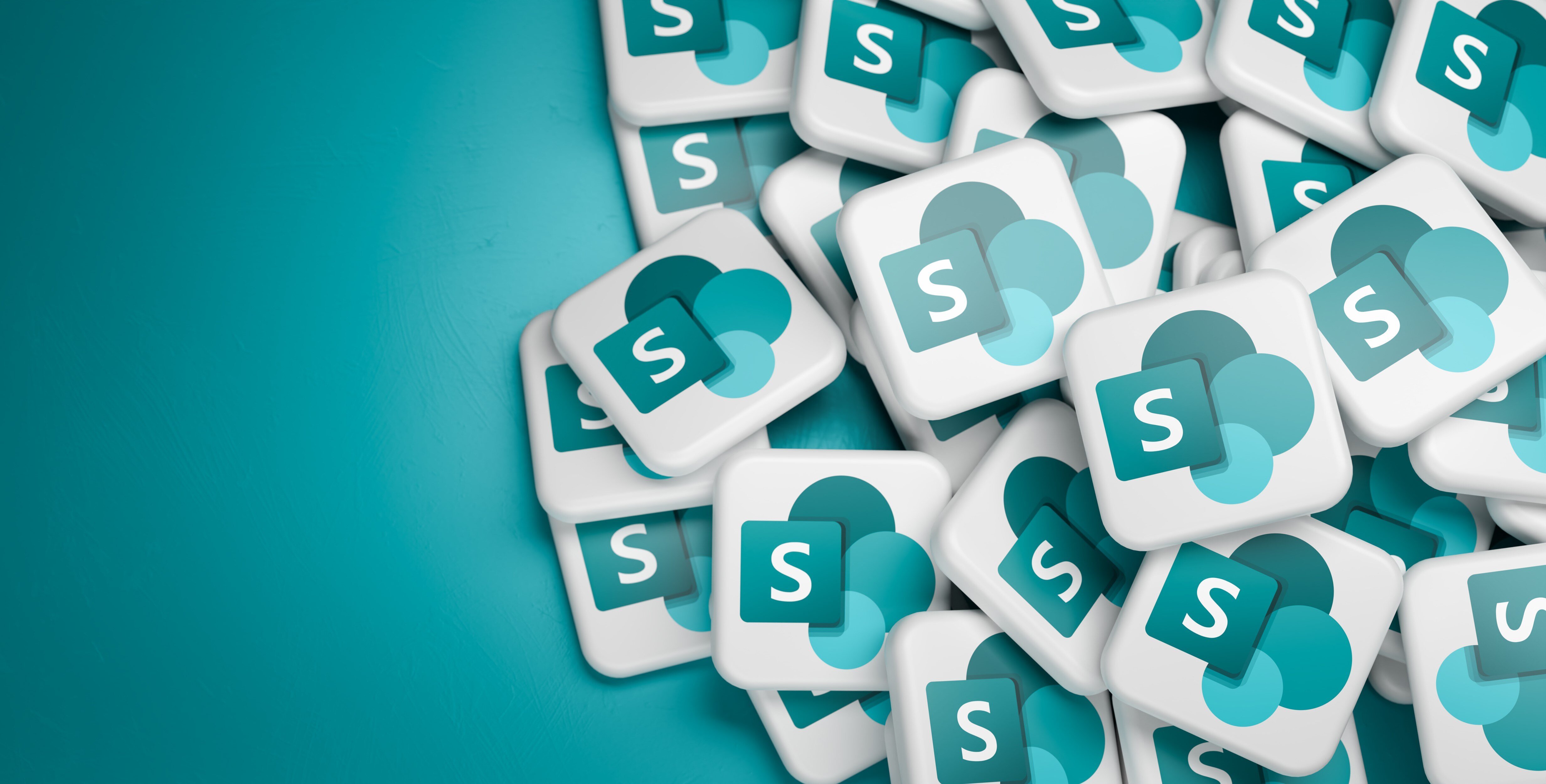 Logos of the Microsoft collaboration platform Sharepoint on a heap on a table.