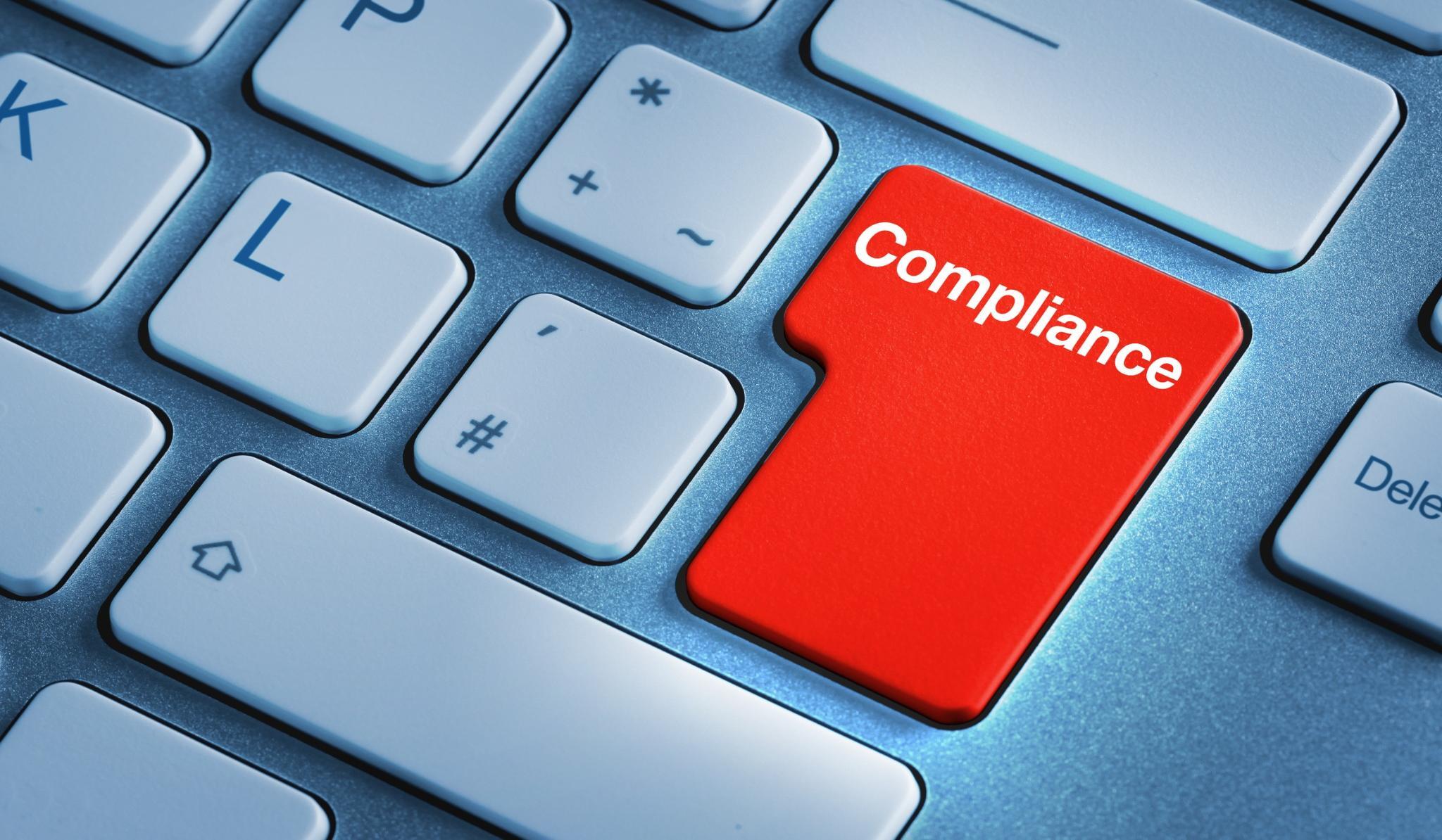 zoomed in picture of a keyboard with a red Compliance enter key
