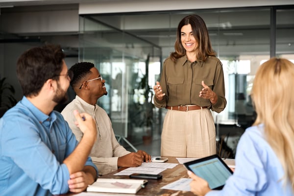 Happy business woman executive ceo leader discussing project management planning strategy working with diverse colleagues company team at office corporate board group meeting