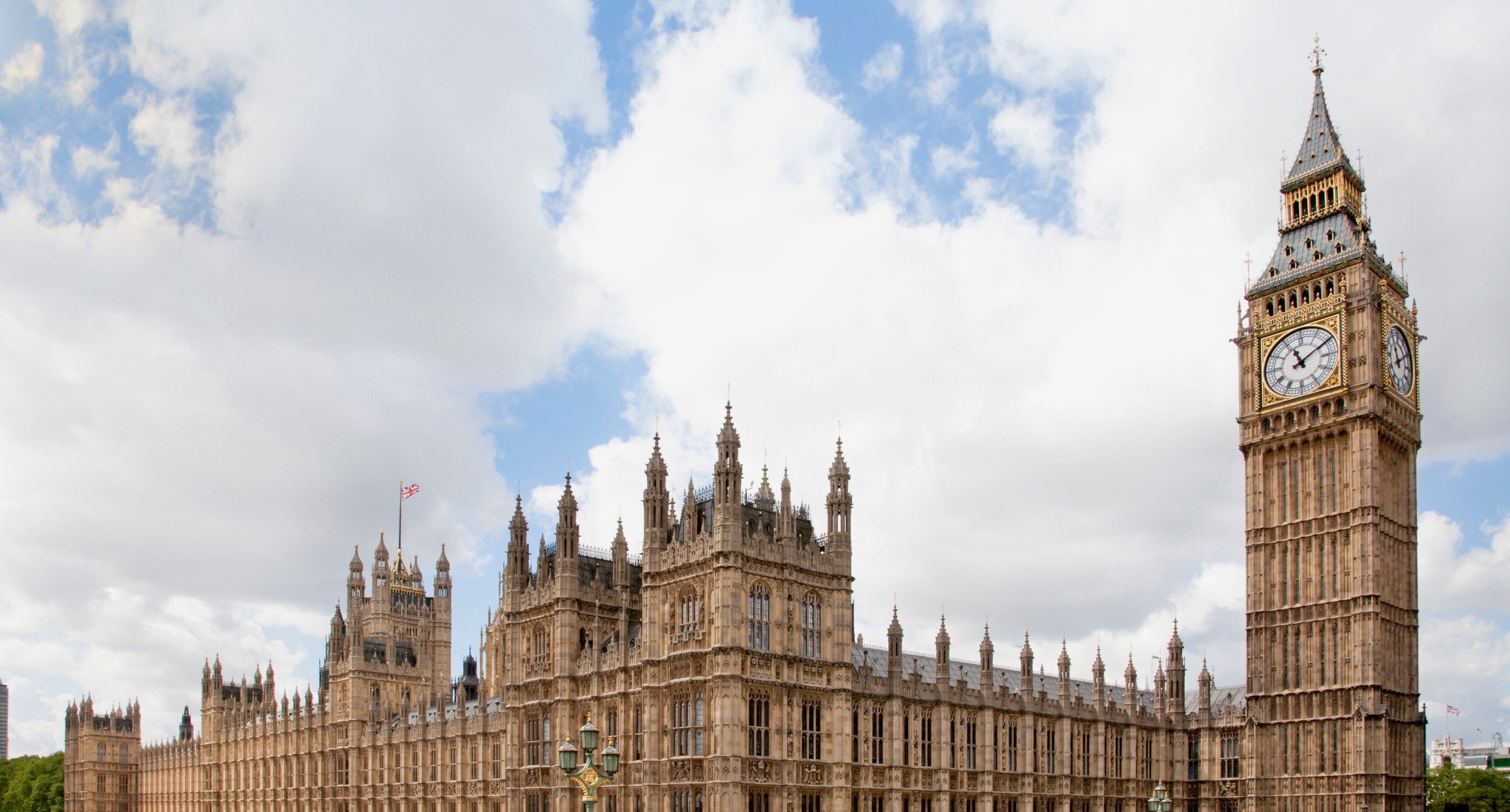 Wide angle of the Big Ben clock tower and Parliament architecture with blue skies with clouds.
