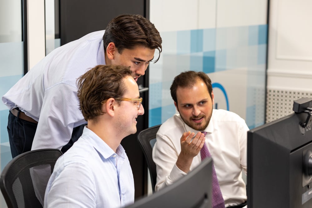 Fitzrovia IT sales team discussing support around a computer screen.