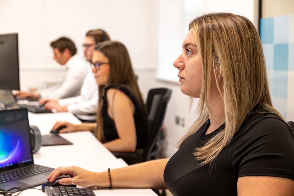 Service desk analyst at Fitzrovia IT typing at her desk while resolving a support ticket