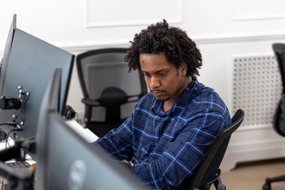 Support engineer working at his desk in the service desk team's office