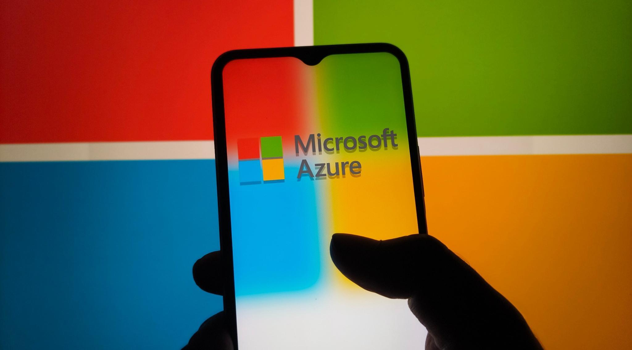 Microsoft Azure logo on phone screen and a microsoft logo projection over it