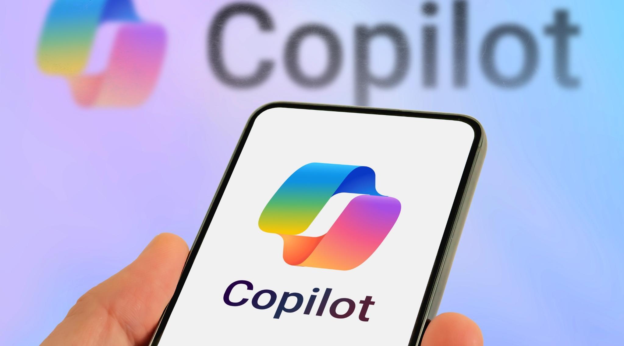 Person holding a phone showing Copilot